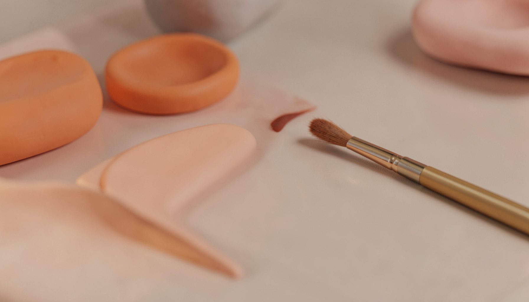 Primer plano de unas cejas bien definidas junto a pinzas y un lápiz sobre un tocador en tonos neutros.