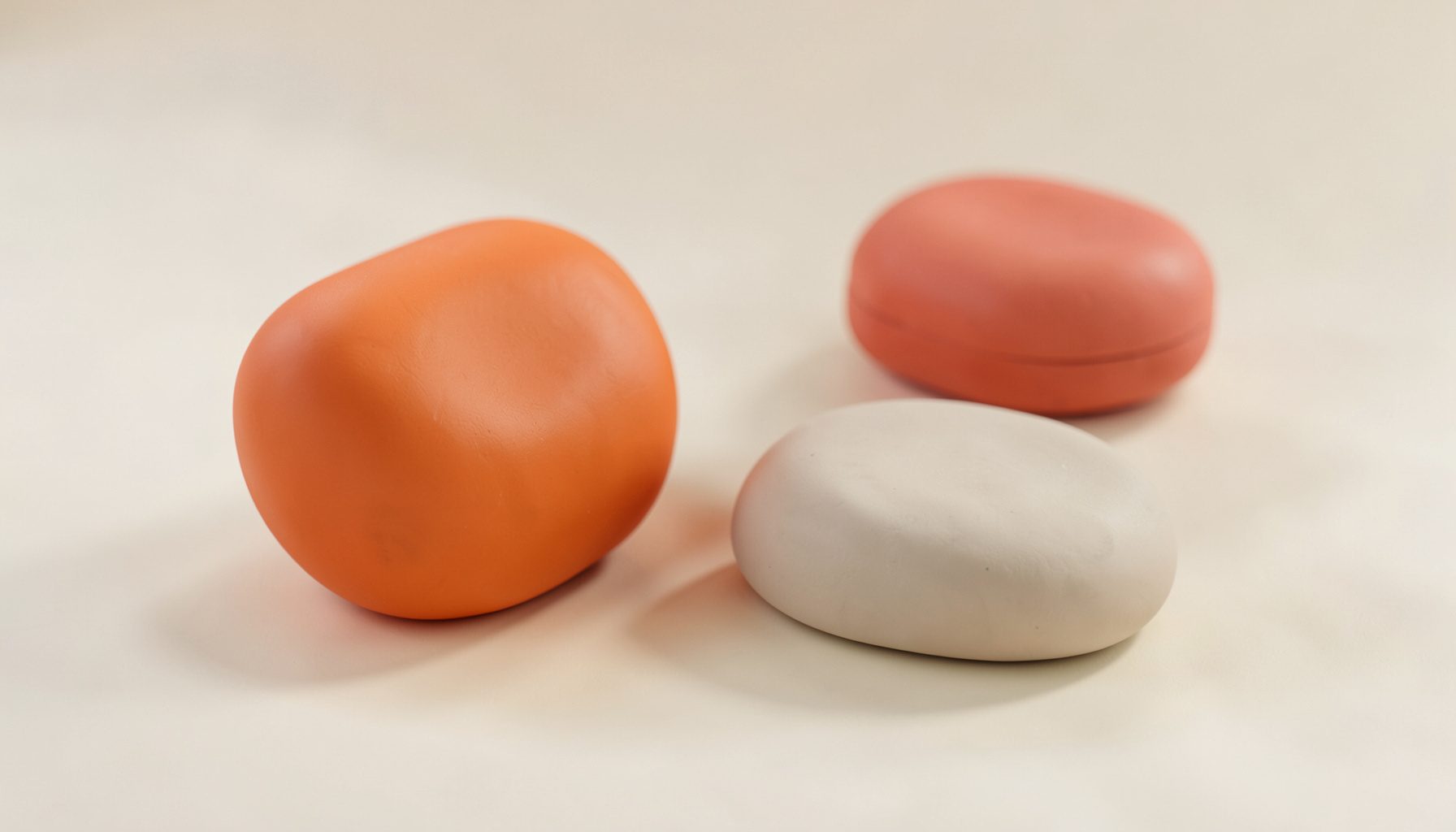 Superficie suave en tonos crema con formas redondeadas de cosmética, atmósfera luminosa y delicada.