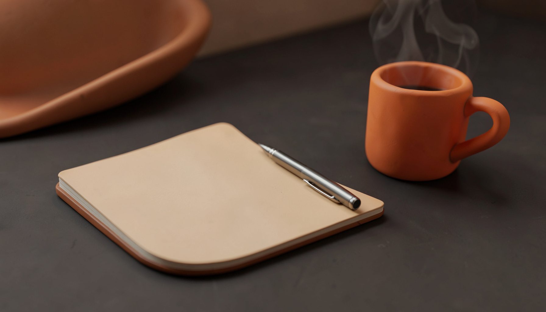 Superficie de escritorio en tonos oscuros con una libreta abierta, un bolígrafo metálico y una taza de café humeante, iluminación cálida.