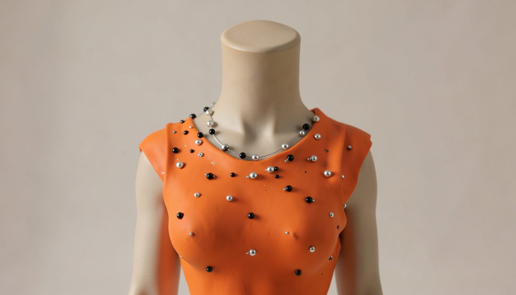 Prenda con lentejuelas plateadas y negras sobre un maniquí, con reflejos que capturan la luz de forma festiva.